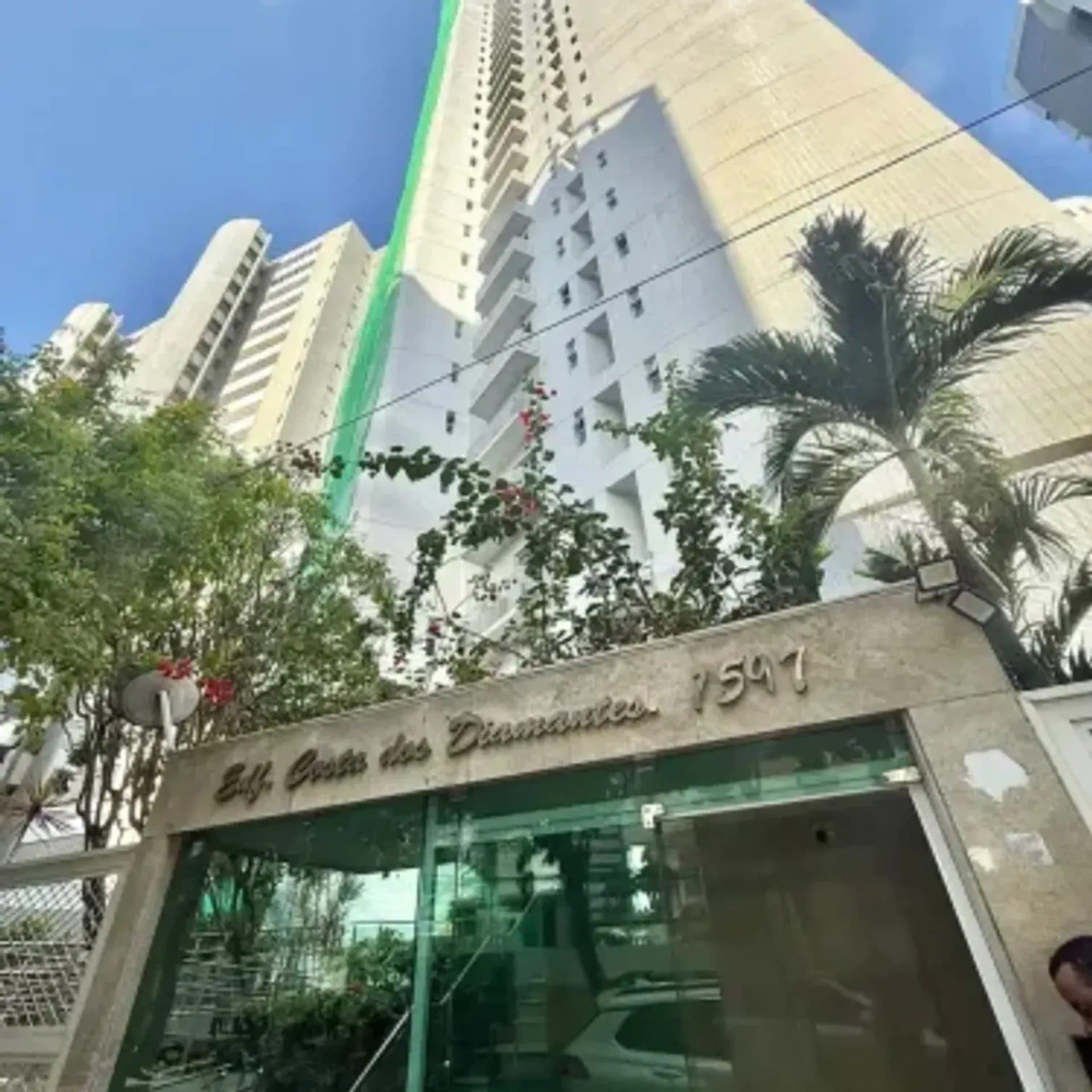 Fachada frontal do edifício Edifício Costa dos Diamantes com letreiro e palmeiras